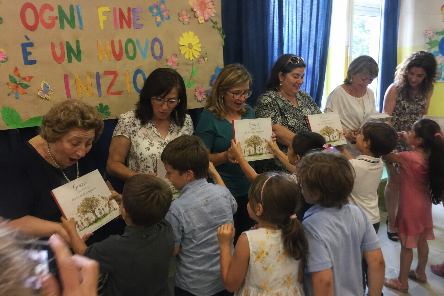 Bambini consegnano un libro personalizzato alle maestre